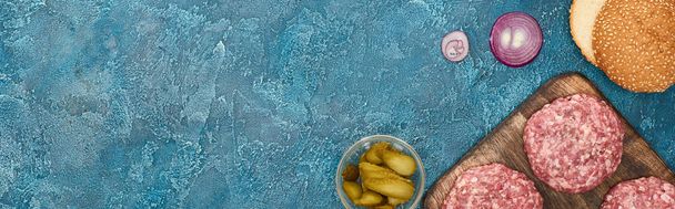 вид сверху на свежие ингредиенты бургера на голубой текстурированной поверхности, панорамный снимок
 - Фото, изображение