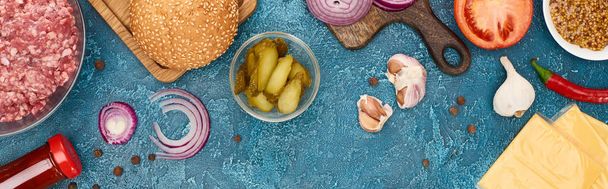 Draufsicht auf frische Burger-Zutaten auf blau strukturierter Oberfläche, Panoramaaufnahme - Foto, Bild