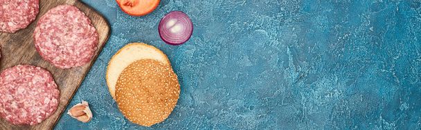Mavi desenli yüzeydeki taze hamburgerlerin üst görünümü kopya alanı, panoramik çekim - Fotoğraf, Görsel