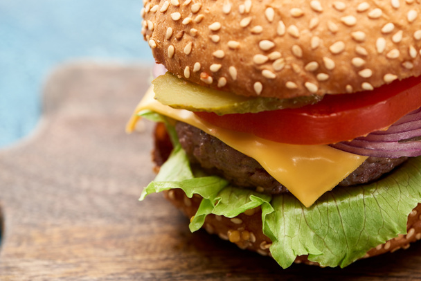 close up view of delicious cheeseburger on wooden board - Foto, imagen