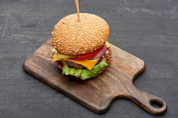 delicious fresh cheeseburger on wooden board - Foto, Bild