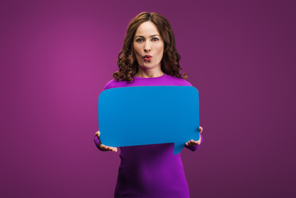 surprised woman holding speech bubble on purple background - Photo, Image