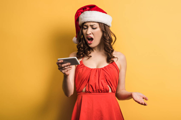 vihainen tyttö jouluhattu huutaa videopuhelun aikana keltaisella taustalla
 - Valokuva, kuva