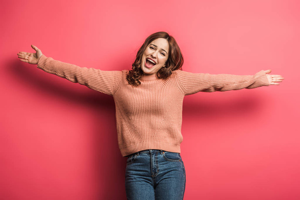 happy girl standing with open arms on pink background - Foto, Imagem