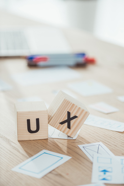 Selective focus of cubes with ux letters and website app layouts on wooden table - Foto, Imagem