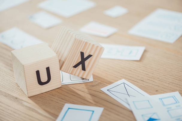 Selective focus of wooden cubes with ux letters and application layouts on table - Photo, Image