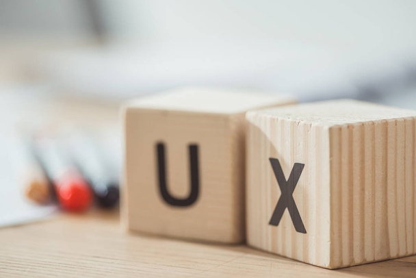 Επιλεκτική εστίαση των ξύλινων κύβων με ux γράμματα στο τραπέζι - Φωτογραφία, εικόνα