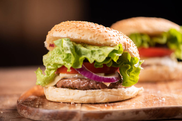 Verse lekkere hamburger en frietjes op houten tafel - Foto, afbeelding