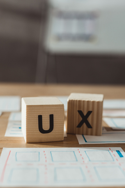 Selective focus of cubes with ux letters and layouts of user experience design on table - Photo, Image