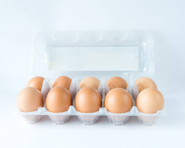 Estudio tiro tapa abierta bandeja de plástico con diez huevos de pollo criados pastoreados aislar en blanco
 - Foto, imagen