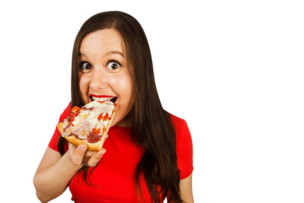 Young beautiful woman eats pizza and smiles, isolated on white background - Foto, Bild