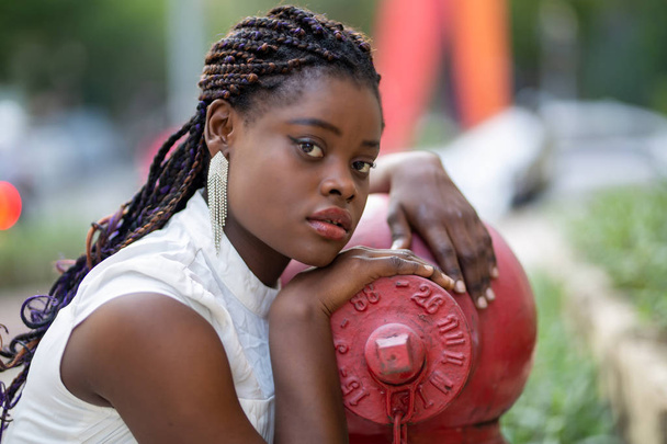 Porträt eines attraktiven Afroamerikaners mit lockiger Frisur gegen die Straße - Foto, Bild