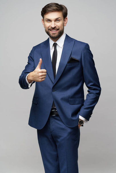 young business man going thumb up on grey background - Φωτογραφία, εικόνα