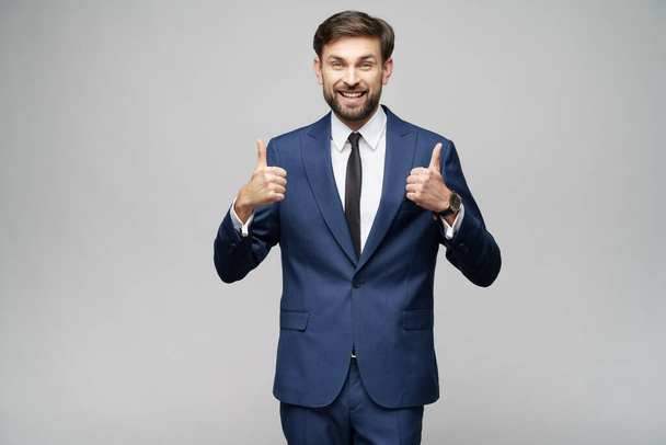 young business man going thumb up on grey background - Фото, зображення