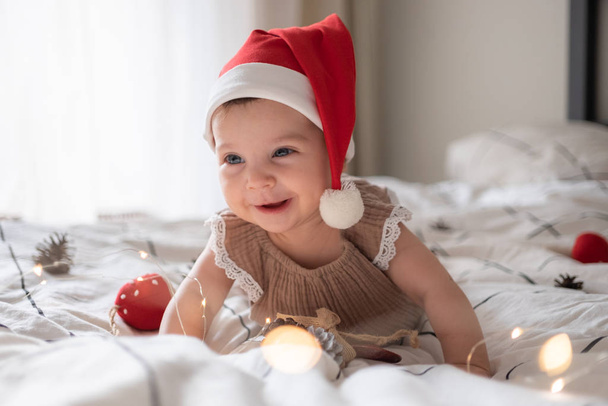 little cute baby girl portreit in red christmas santa hat with lights - Foto, afbeelding