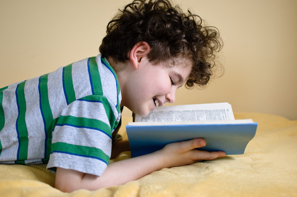 Boy reading book at home - Фото, изображение