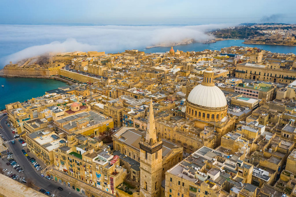 Aerial view of Valletta, dome, church. Clouds, fog on blue sky. Europe. Malta island - Photo, Image