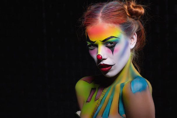 Pretty young woman with a face painting clown - Photo, Image