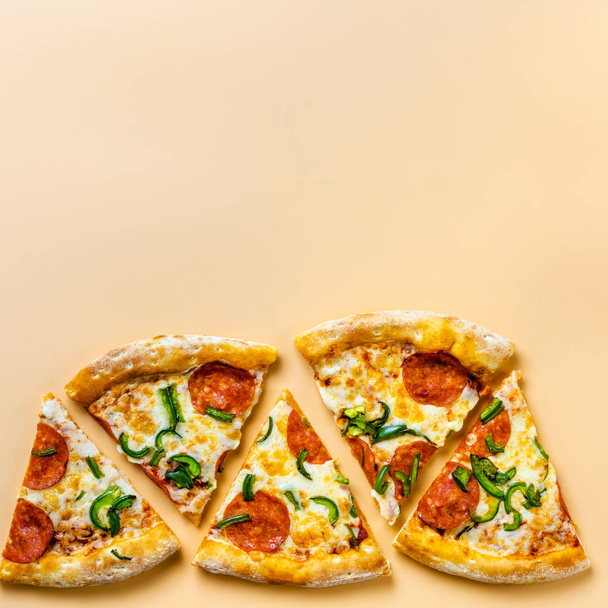 Pieces of pizza on a beige background. Space for text. Pizza menu. Birthday with junk food. - Foto, afbeelding