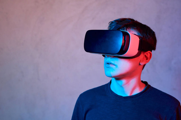Jeune homme utilisant casque de réalité virtuelle
 - Photo, image