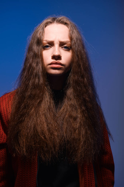 Tennage girl with fluffy hair posing on blue background - Valokuva, kuva