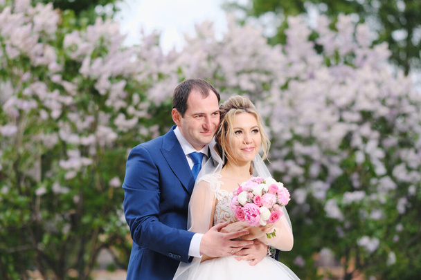 Bonitos recém-casados posando no parque da primavera
 - Foto, Imagem