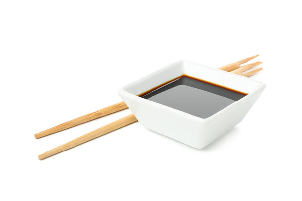 Соевый соус и палочки для еды на белом фоне
 - Фото, изображение