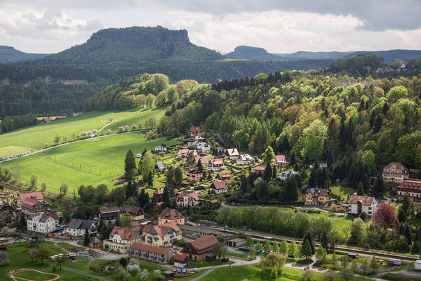 El pequeño pueblo de Rathen con el Lilienstein en el fondo
 - Foto, Imagen