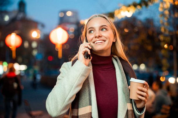 Smiling pretty woman with mobile phone in the city - Photo, Image