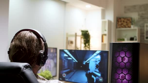 Over shoulder shot of man with long hair playing shooter games - Footage, Video