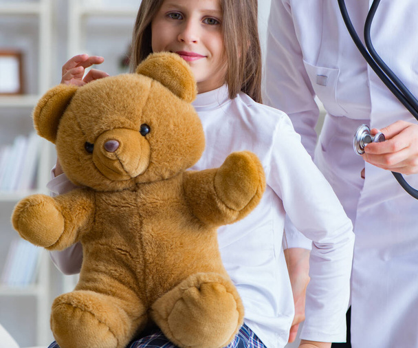 kobieta lekarz egzaminowanie mało słodkie dziewczyna z zabawka niedźwiedź - Zdjęcie, obraz