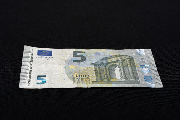 Detail van 5 eurobankbiljetten met hologrammen tegen valsemunterij, Selectieve focus, zwarte achtergrond, één bankbiljet. - Foto, afbeelding