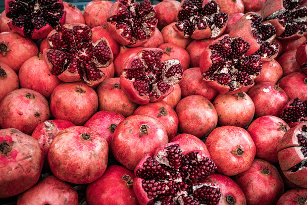 Many pomegranate cut in half, pomegranate background - Foto, afbeelding
