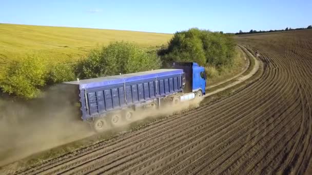 Widok z lotu ptaka ciężarówki jadącej po polnej drodze między polami ornymi wytwarzającymi dużo pyłu. - Materiał filmowy, wideo