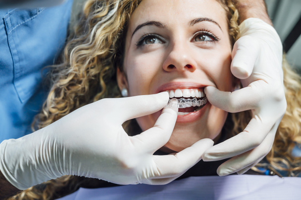 Az orvos átlátszó fogászati alsót ad a beteg nőnek. - Fotó, kép