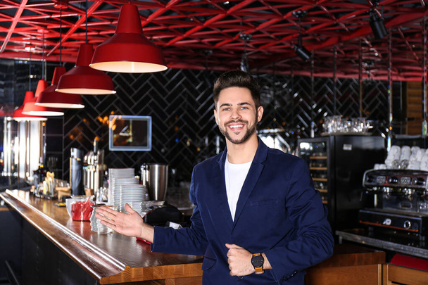 Jeune propriétaire d'entreprise debout près du comptoir dans son café
 - Photo, image