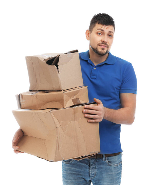 Emotional courier with damaged cardboard boxes on white background. Poor quality delivery service - Fotoğraf, Görsel