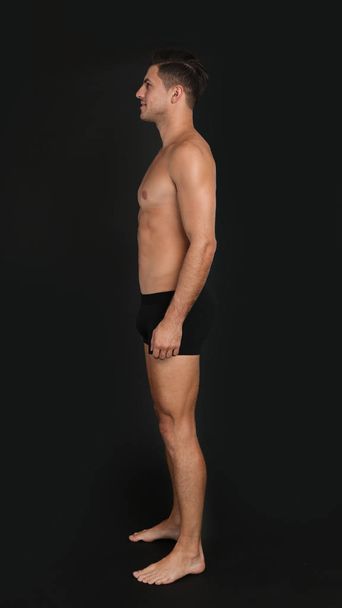 Handsome man in underwear on black background - Foto, imagen