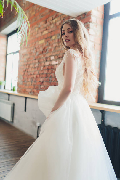 The beautiful woman posing in a wedding dress. - Valokuva, kuva