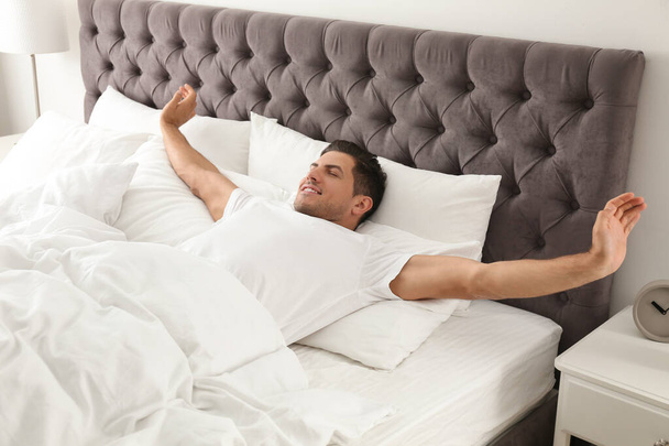 Man awakening on bed at home. Lazy morning - Foto, Imagen