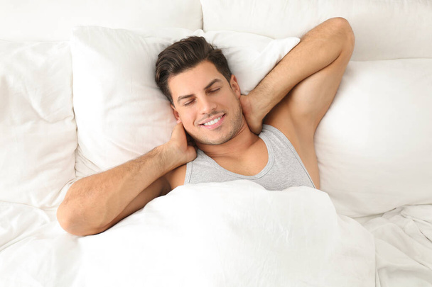 Man awakening in bed at home, top view. Lazy morning - Foto, Imagem