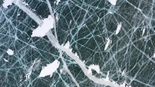 Fagyasztott Bajkál-tó, Bajkál-tó. Gyönyörű téli táj tiszta, sima jéggel a sziklás part közelében. A híres természeti mérföldkő Oroszország. Kék átlátszó jég mély repedésekkel. - Felvétel, videó