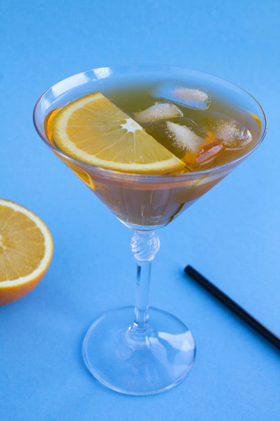 Aperol spritz koktél martinis pohárban a kék háttérben. Másold a helyet. Függőleges elhelyezkedés. - Fotó, kép