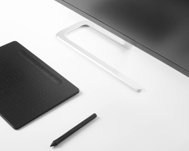 Grafik tablet kalem ve beyaz bir masada beyaz bir masa üzerinde monitör - Fotoğraf, Görsel