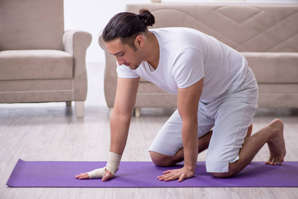 Hand injured man doing exercises at home - Photo, Image