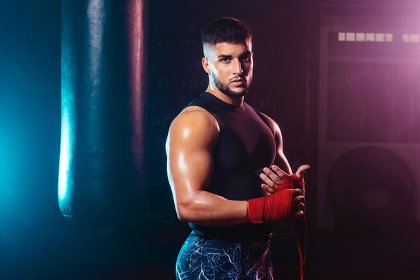 homem jovem e musculoso envolvendo suas mãos com fita de boxe mãos luta, esporte e boxe temas
 - Foto, Imagem
