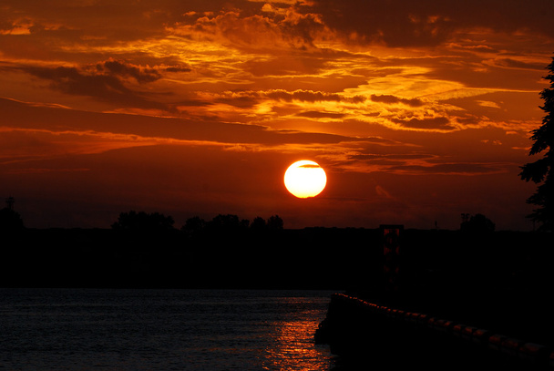 východ slunce na břehu řeky. Ventspils, Lotyšsko - Fotografie, Obrázek