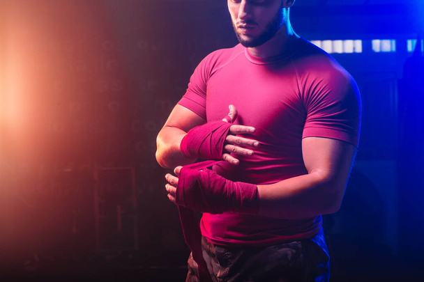Ellerini boks bandıyla saran güçlü bir adam - kapan - dövüş, spor ve boks temaları - Fotoğraf, Görsel