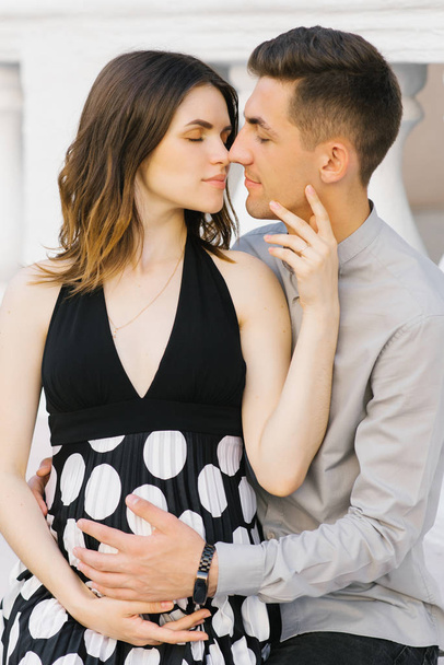 Un giovane uomo e donna di famiglia in attesa del loro primo figlio, un bacio
 - Foto, immagini
