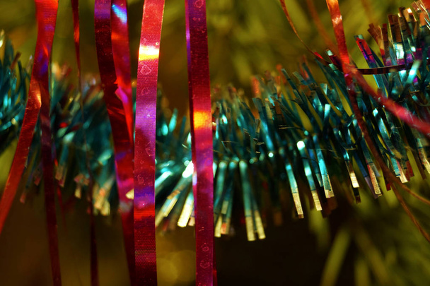 Bright and shiny decorations for Christmas and New Year hang on a green spruce. Winter holidays. - 写真・画像